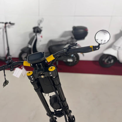 Na sliki je električni skiro znamke Vsett, model 11 Super. Vidni so krmili s črnimi in rumenimi detajli, digitalni zaslon ter ogledalo na desni strani. V ozadju so vidni drugi skiroji in vozila, kar nakazuje, da je izdelek razstavljen v trgovini ali na razstavi.