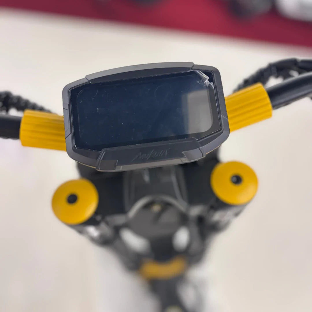 Na sliki je električni skiro znamke Vsett, model 11 Super. Vidna je nadzorna plošča skiroja, ki ima velik zaslon, ter ročaji z rumenimi detajli. Na sliki so tudi vidni deli koles in okvir skiroja, kar nakazuje na robustno zasnovo in zmogljivost.