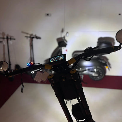 Na sliki je električni skiro znamke Vsett, model 11 Super. Vidni so krmili s prikazovalnikom, ki prikazuje hitrost in druge informacije. Na krmilu so tudi luči in ogledala, kar nakazuje na funkcionalnost in varnost pri vožnji. V ozadju so še drugi skiroji, kar daje občutek razstave ali prodajnega prostora.