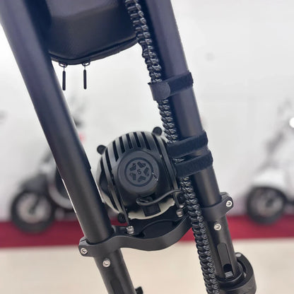 Na sliki je električni skiro znamke Vsett, model 11 Super. Vidna je podrobnost motorja, ki je nameščen na okvirju skiroja, ter del konstrukcije, ki vključuje cev in pritrdilne elemente. Ozadje slike prikazuje še druge električne skiroje, kar nakazuje na okolje prodajalne ali razstave.