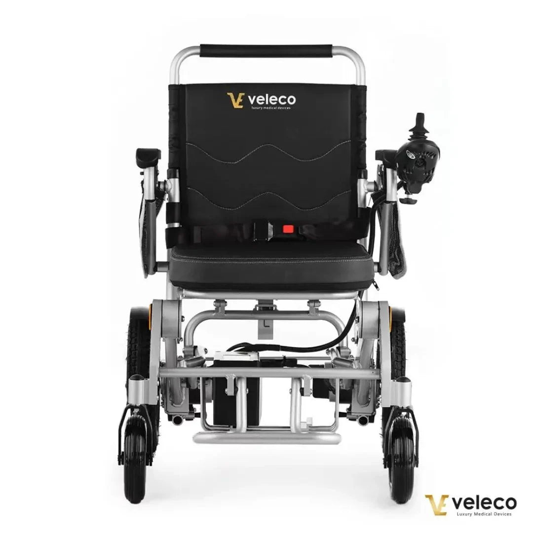 Izdelek na sliki je električni invalidski voziček znamke Veleco, model Cosmo. Na sliki je prikazan voziček s črnim oblazinjenjem in ergonomskim naslonjalom. Ima krmilno napravo na desni strani, ki omogoča enostavno upravljanje. Konstrukcija je iz aluminija, kar zagotavlja lahkost in trdnost, medtem ko so kolesa zasnovana za gladko vožnjo.