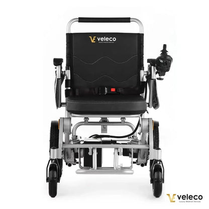 Izdelek na sliki je električni invalidski voziček znamke Veleco, model Cosmo. Na sliki je prikazan voziček s črnim oblazinjenjem in ergonomskim naslonjalom. Ima krmilno napravo na desni strani, ki omogoča enostavno upravljanje. Konstrukcija je iz aluminija, kar zagotavlja lahkost in trdnost, medtem ko so kolesa zasnovana za gladko vožnjo.