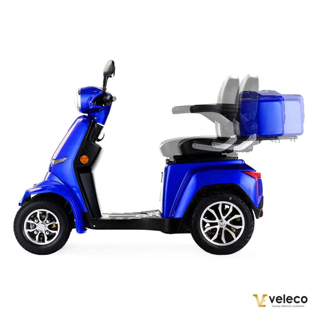 Izdelek je električni skuter, znamke Veleco, model Gravis. Na sliki je prikazan stranski pogled skuterja, ki je v svetlo modri barvi. Ima široko sedežno površino in prostoren prostor za shranjevanje. Opremljen je z večjimi kolesi, kar omogoča udobno vožnjo. Sedež je prilagodljiv, kar je vidno iz mehanizma za pomik. Skuter je zasnovan za udobno in enostavno mobilnost.