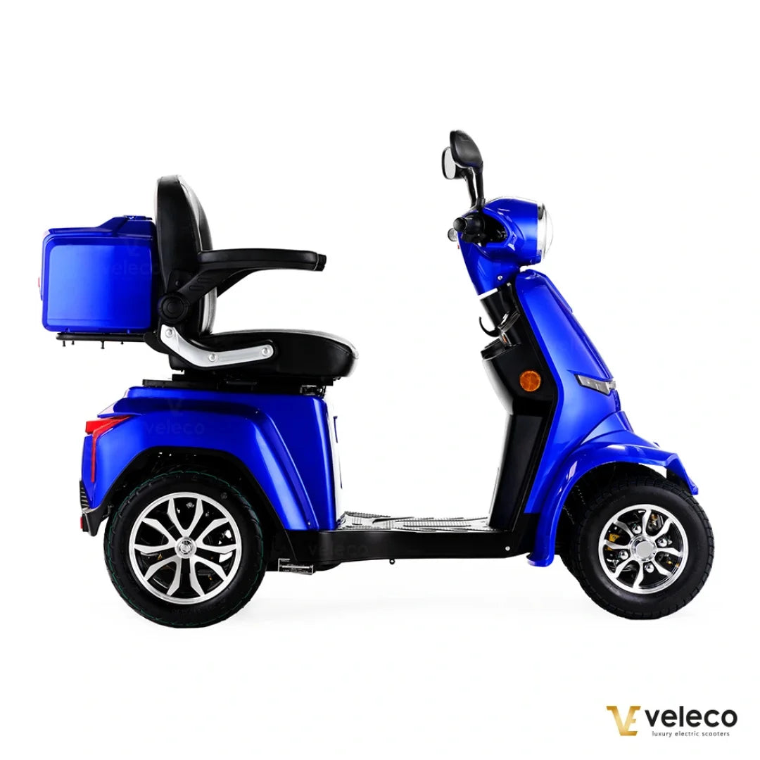 Izdelek na sliki je električni skuter, znamke Veleco, model Gravis. Na sliki je prikazan stranski pogled na skuter v modri barvi, ki ima udobno sedežno površino in prtljažnik na zadnjem delu. Skuter je zasnovan za udobno vožnjo in enostavno manevriranje.