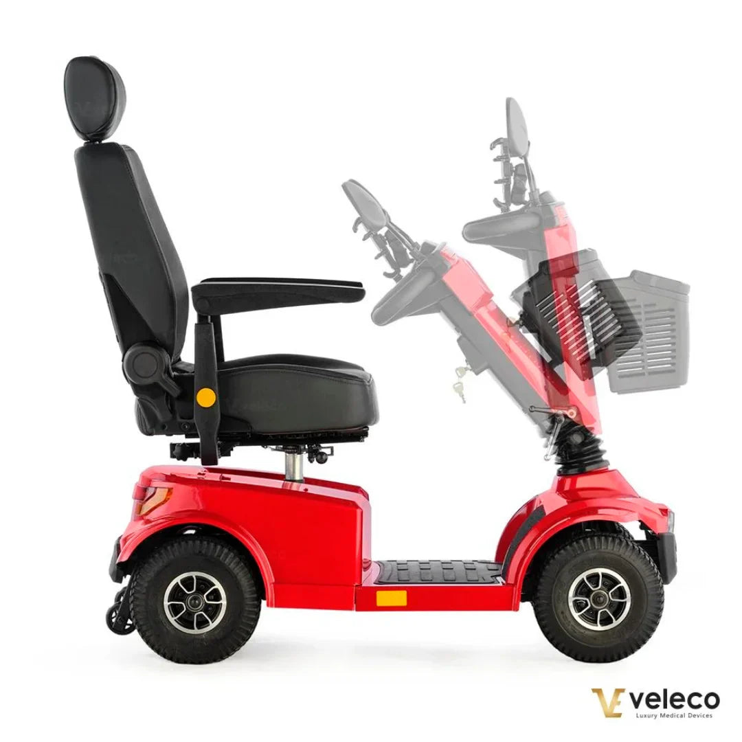 Izdelek je električni skuter, natančneje model Veleco Jumpy. Na sliki je prikazana rdeča električna mobilnostna skuter, ki ima udoben sedež s hrbtno oporo in naslonjali za roke. Vidna je tudi krmilna enota, ki omogoča enostavno upravljanje. Skuter je zasnovan za udobno in varno vožnjo, kar je še posebej pomembno za uporabnike z omejeno mobilnostjo.