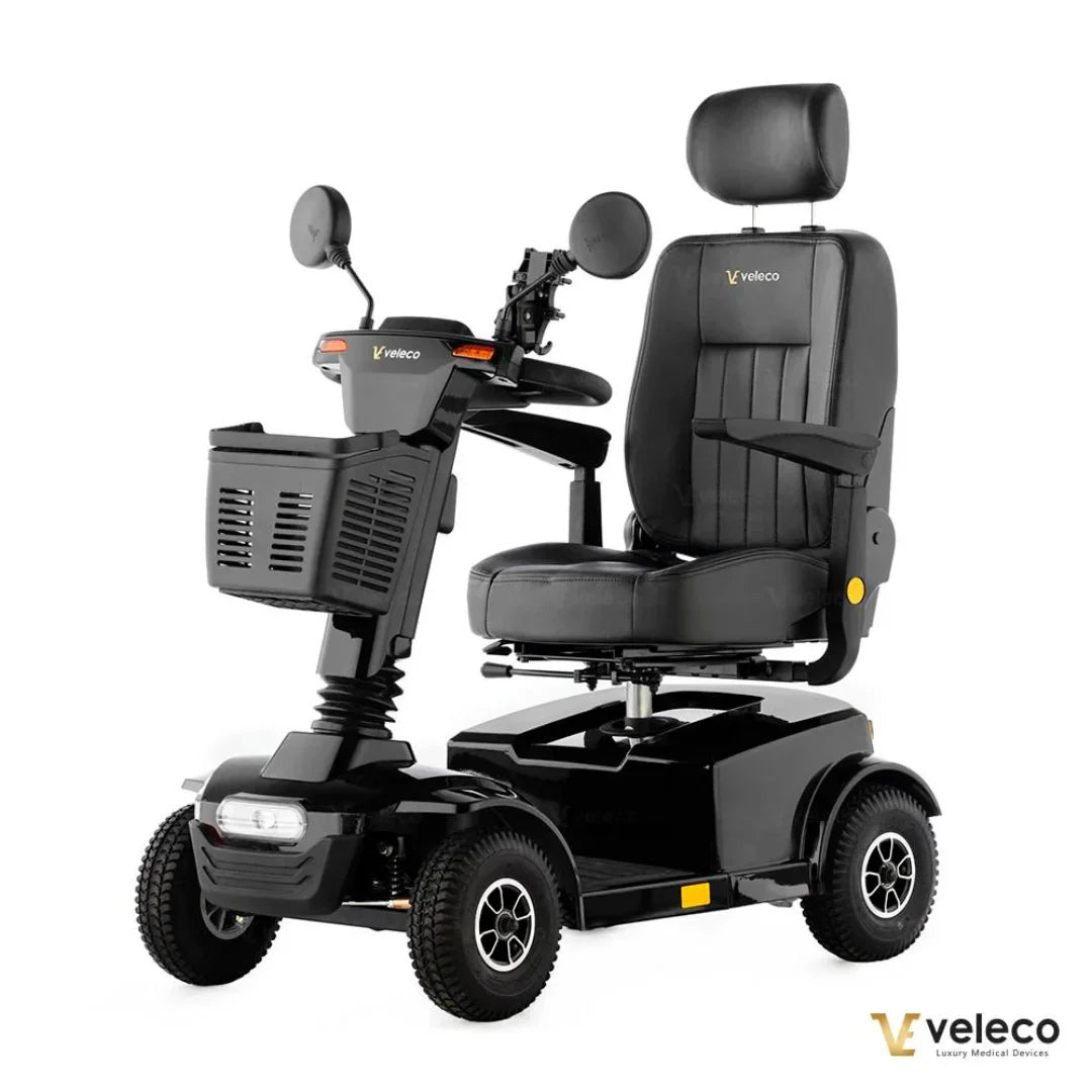Izdelek na sliki je električni skuter, natančneje model Veleco Jumpy. Na sliki je vidna črna električna mobilnostna naprava s širokim sedežem in naslonjalom za glavo. Skuter ima tudi ogledala, krmilo in sprednji koš za shranjevanje. Njegova zasnova je namenjena udobni in varni vožnji, kar ga dela primernega za uporabnike, ki potrebujejo pomoč pri mobilnosti.