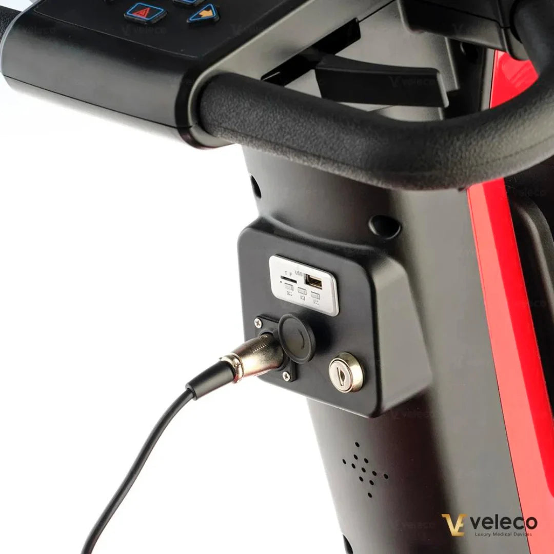 Izdelek je električni skuter, model Veleco Jumpy. Na sliki je vidna nadzorna plošča z gumbi za upravljanje, priključek za polnjenje in USB izhodi. Skuter ima sodoben dizajn in je zasnovan za enostavno uporabo ter udobno vožnjo.