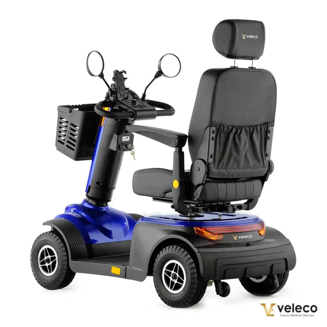 Izdelek je električni skuter, model Veleco Looper. Na sliki je prikazan skuter v modri barvi z udobnim sedežem in naslonjalom, ter krmilom, ki vključuje ogledala. Vidna je tudi sprednja košara za shranjevanje. Skuter je zasnovan za udobno in enostavno vožnjo, kar ga naredi primernega za različne uporabnike.