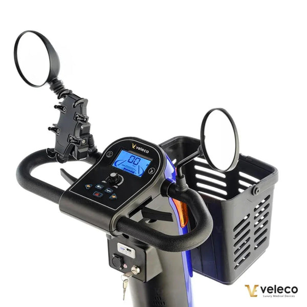 Izdelek je električni skuter, znamke Veleco, model Looper. Na sliki je prikazan krmni del skuterja, kjer so vidni digitalni zaslon, ročaji in ogledali. Ob strani je tudi košara za shranjevanje, kar omogoča dodatno funkcionalnost pri vožnji.