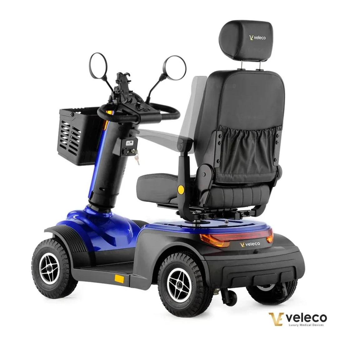 Izdelek na sliki je električni skuter, model Veleco Looper. Na sliki je prikazan skuter v modri barvi, opremljen z udobnim sedežem, krmilom in ogledali. Vidna je tudi sprednja košara za shranjevanje, kar omogoča priročno prevažanje manjših predmetov. Skuter je zasnovan za udobno in enostavno mobilnost.