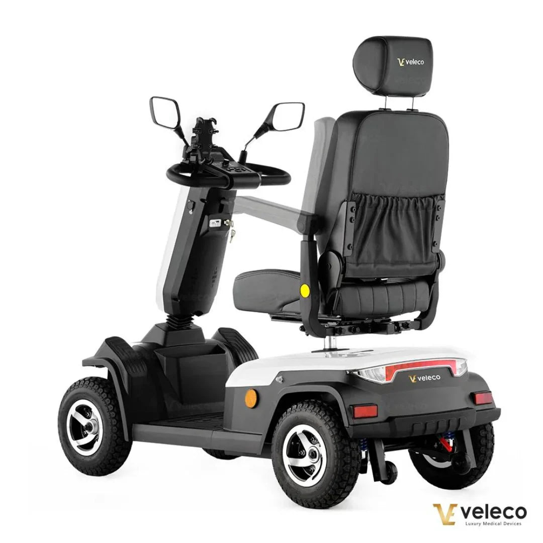 Izdelek je električni skuter, model Veleco Sharpy. Na sliki je vidna zasnova skuterja, ki vključuje široko sedežno površino, ergonomski naslon za hrbet ter krmilo z upravljalnimi elementi. Skuter ima robustne pnevmatike in stabilno podvozje, kar omogoča udobno in varno vožnjo. Znamka Veleco se osredotoča na luksuzne medicinske naprave.