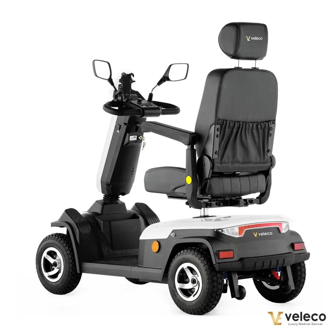 Izdelek na sliki je električni skuter, model Veleco Sharpy. Na sliki je prikazan skuter z udobnim sedežem in krmilom, opremljenim z ogledali. Ima široke pnevmatike, kar omogoča stabilno vožnjo, in je zasnovan za udobno in varno mobilnost. Znamka Veleco se osredotoča na luksuzne medicinske naprave.