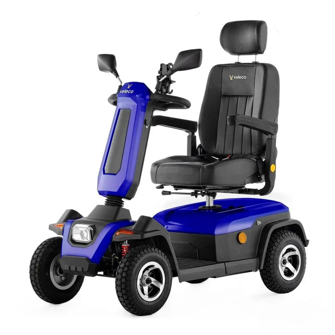 Izdelek na sliki je električni skuter, model Veleco Sharpy. Vidna je modra karoserija s črnim sedežem, ki ima naslonjalo in naslona za roke. Skuter ima tudi krmilo z ogledali in sprednjo lučjo, kar kaže na njegovo funkcionalnost in udobje pri vožnji. Kolesa so robustna, kar omogoča stabilno vožnjo po različnih površinah.