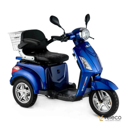 Izdelek je električni mobilni voziček znamke Veleco, model ZT15. Na sliki je prikazan modri voziček s širokim sedežem in naslonjalom, ter sprednjim kolesom in košarico za shranjevanje. Vozilo je zasnovano za udobno vožnjo in enostavno manevriranje.