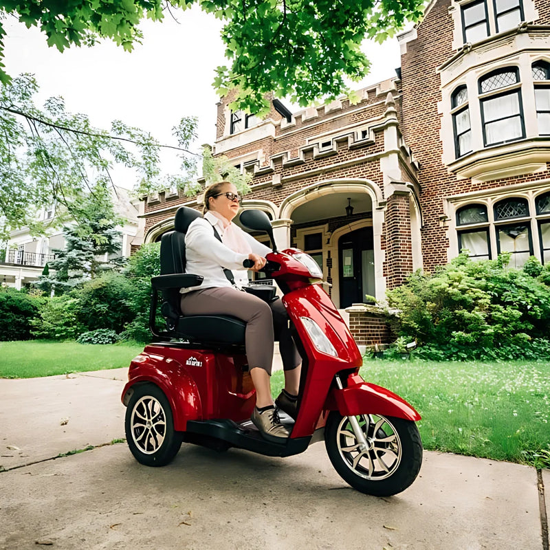 Ženska se vozi z električnim mobilnim vozičkom Veleco Zt15 pred veliko hišo iz opeke.