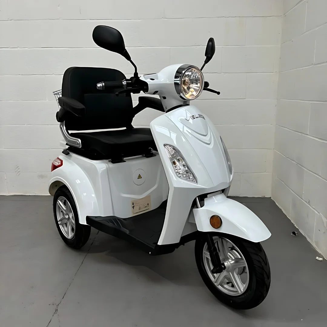 Bel električni mobilni voziček Veleco ZT15 parkiran v zaprtih prostorih, z elegantnim dizajnom in udobnim sedežem.