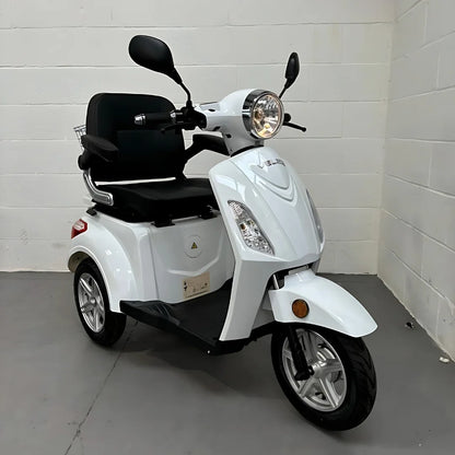 Bel električni mobilni voziček Veleco ZT15 parkiran v zaprtih prostorih, z elegantnim dizajnom in udobnim sedežem.