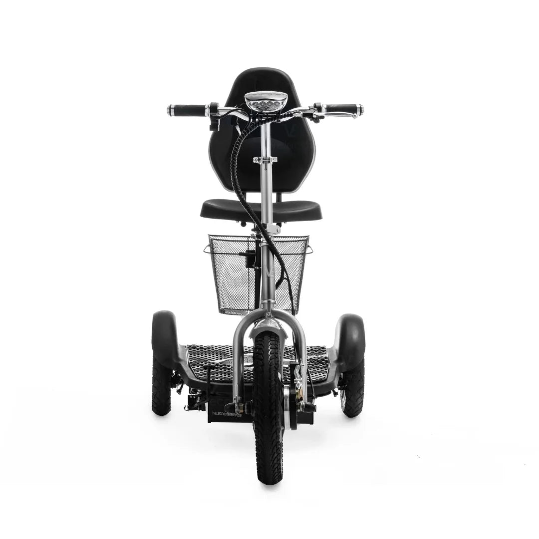 Izdelek je električni mobilni voziček, model Veleco ZT16. Na sliki je prikazan sprednji del vozička, ki ima udobno sedežno mesto in krmilo. Vidna je tudi kovinska košara spredaj, ki omogoča shranjevanje manjših predmetov. Voziček ima široke pnevmatike, kar zagotavlja stabilnost in udobno vožnjo.