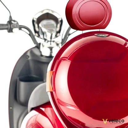 Izdelek je električni mobilni voziček, model ZT63, znamke Veleco. Na sliki je vidna zadnja stran vozička v svetlo rdeči barvi, s kromiranimi detajli in udobnim sedežem. V ozadju se vidi krmilo z merilniki, kar nakazuje na funkcionalnost in udobje vožnje.