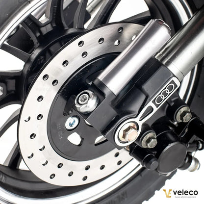 Izdelek je električni mobilni voziček, model ZT63, znamke Veleco. Na sliki je prikazan del kolesa, ki vključuje disk zavoro in del mehanizma za zaviranje. Vidna je tudi aluminijasta cev in del kolesa, kar nakazuje na robustno in kakovostno zasnovo.