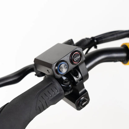 Na sliki je prikazan električni skiro znamke Vsett, model 11 Super. Vidni so ročaji skiroja z dvema gumboma na nadzornem pultu, označenima kot "Sport" in "DDM", kar nakazuje na različne načine vožnje. Ročaji so ergonomsko oblikovani za udobno držanje med vožnjo.