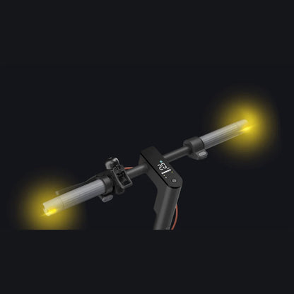 Na sliki je električni skiro znamke Xiaomi, model 5 Pro. Vidni so krmili s svetlobnimi indikatorji na obeh straneh, kar povečuje vidnost med vožnjo. Na sredini krmila je tudi digitalni zaslon, ki prikazuje pomembne informacije, kot je hitrost. Celoten dizajn je eleganten in sodoben, kar je značilno za to znamko.