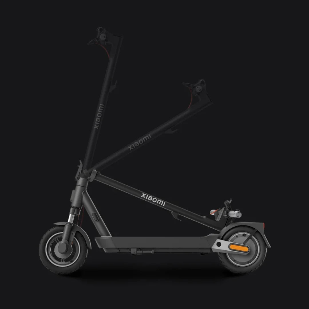 Na sliki je električni skiro znamke Xiaomi, model 5 Pro. Izdelek je prikazan v zloženem položaju, kar omogoča enostavno prenašanje in shranjevanje. Vidna sta tudi sprednja in zadnja kolesa ter del krmila, kar daje vpogled v njegov minimalističen in sodoben dizajn.