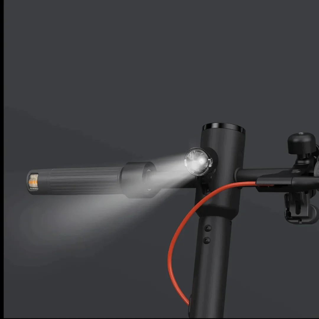 Na sliki je električni skiro znamke Xiaomi, model Elite. Vidna je ročica skiroja s svetilko, ki je nameščena na krmilu, ter rdeč kabel, ki se verjetno povezuje z električnim sistemom. Ozadje je temno, kar poudarja detajle skiroja in svetlobe.