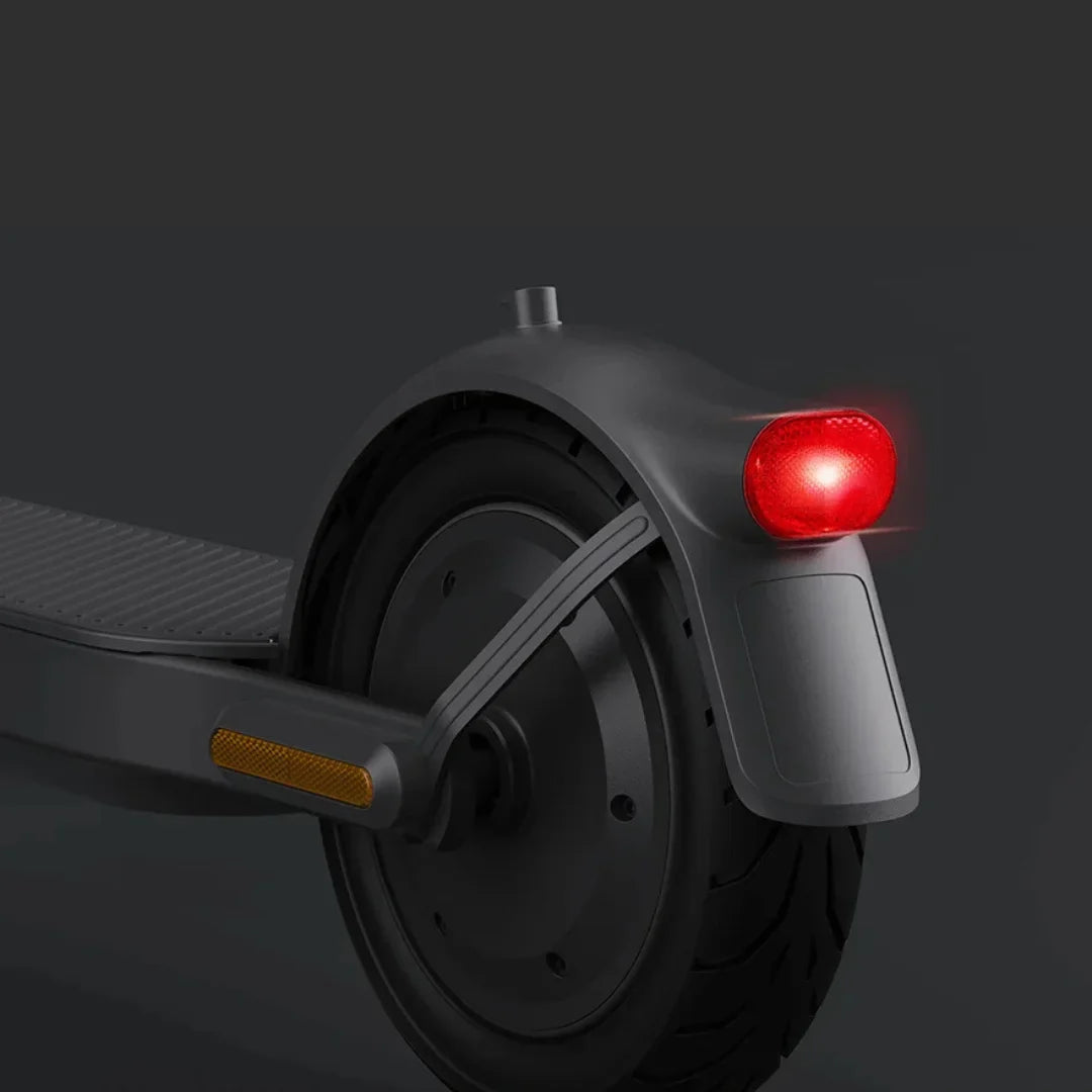 Na sliki je električni skiro znamke Xiaomi, model Elite. Vidna je zadnja kolesa skiroja, ki ima rdečo luč za varnostno osvetlitev ter odsevnike. Oblika in materiali so moderni, kar nakazuje na kakovostno izdelavo.