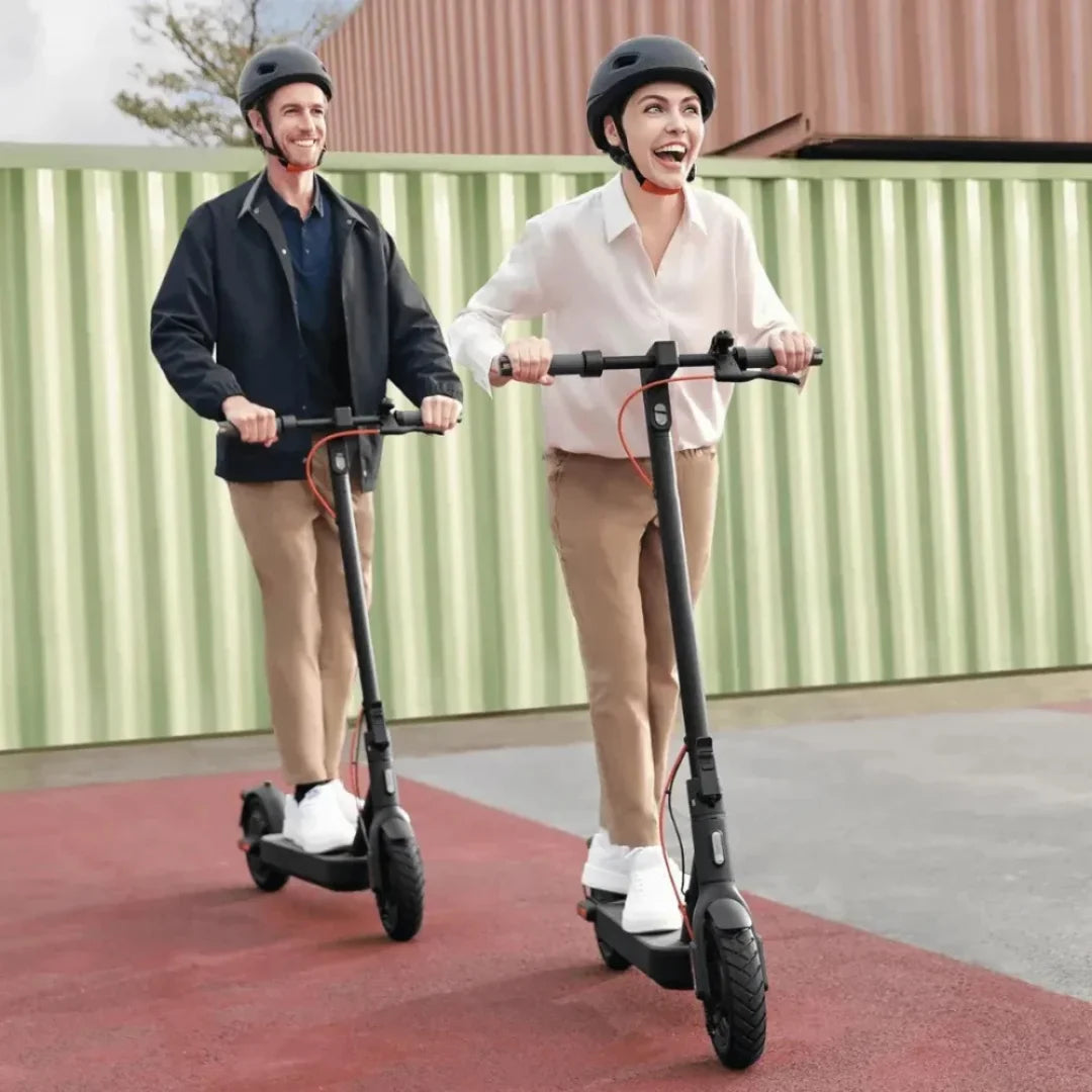 Dve osebi se vozita z električnim skirojem Xiaomi 4 Pro 2. generacije, se smehljata in nosita čelade.