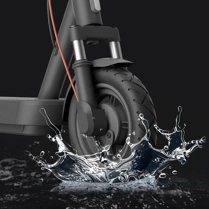 Izdelek na sliki je električni skiro znamke Xiaomi, model 5 Max GL. Na sliki je prikazan sprednji del skiroja, kjer je vidna sprednja pnevmatika, vilice in del platforme. V ozadju je prikazano brizganje vode, kar nakazuje na vodoodpornost in zmogljivost skiroja v različnih vremenskih razmerah.