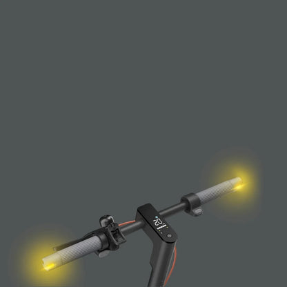 Na sliki je električni skiro znamke Xiaomi, model 5 Max GL. Vidni so ročaji skiroja z vgrajenimi svetili na koncih, ki oddajajo rumeno svetlobo. Na sredini ročajev je digitalni zaslon, ki prikazuje informacije o hitrosti in stanju baterije. Celoten dizajn je eleganten in sodoben, kar je značilno za to znamko.