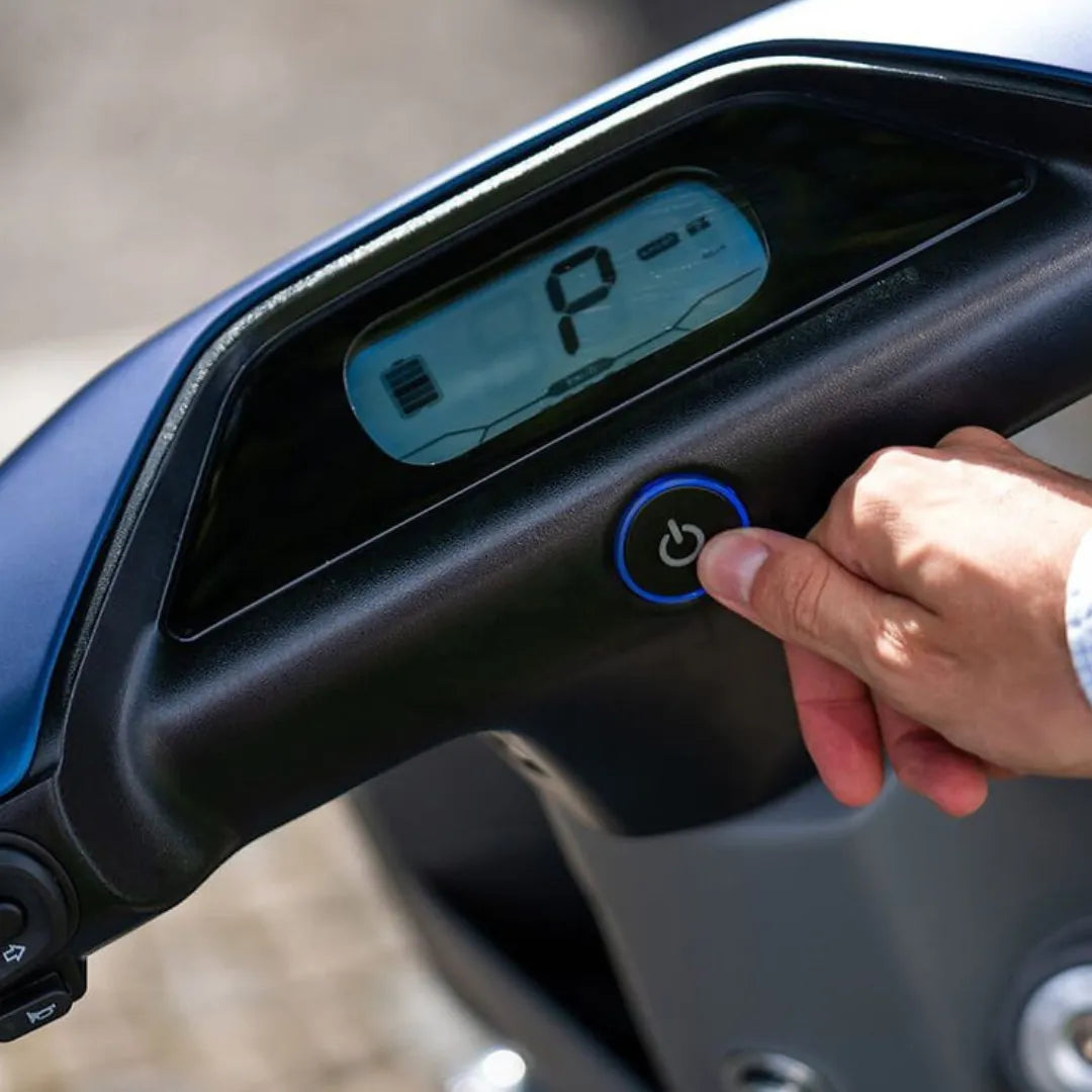 Od blizu posneto armaturno ploščo električnega skuterja Yadea C Line, ki prikazuje gumb za vklop.