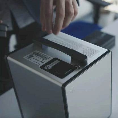 Roka prilagaja baterijo električnega skuterja Yadea C Line na mizi.