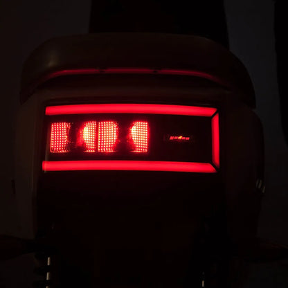 Od blizu posnet zadnji del električnega skuterja Yadea C Line, ki sveti rdeče.