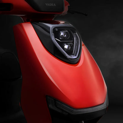 Od blizu posnet Električni skuter Yadea Ezeego, ki prikazuje njegovo elegantno rdečo obliko in žaromete.