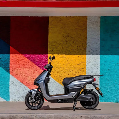 Električni skuter Yadea T9L parkiran ob živahni, pisani steni.