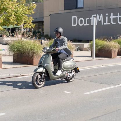 Voznik električnega skuterja Efo Et5000 se vozi po mestni ulici.