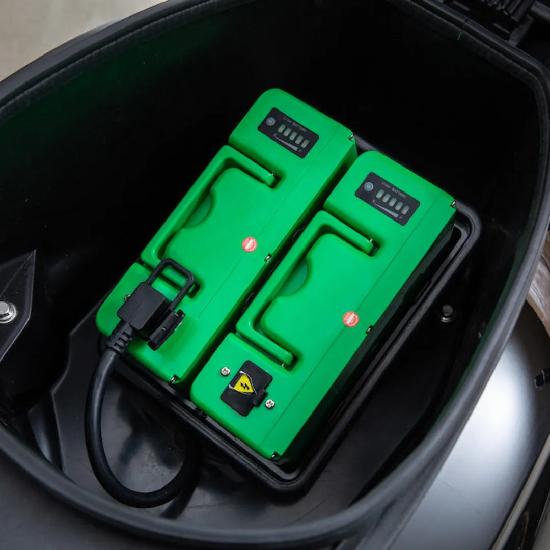 Posnetek od blizu dveh zelenih baterij v notranjosti prostora za shranjevanje električnega skuterja Efo Et3000.