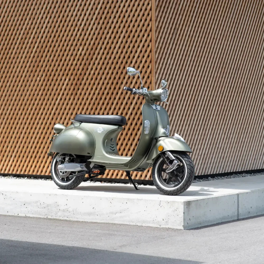 Eleganten električni skuter Efo Ev3000 parkiran ob steni z lesenimi letvicami.