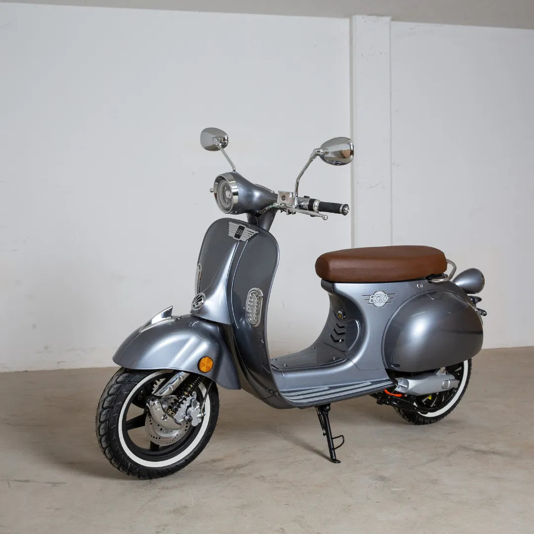 Eleganten siv električni skuter Efo Ev3000 z rjavim sedežem, postavljen pred enostavno ozadje.